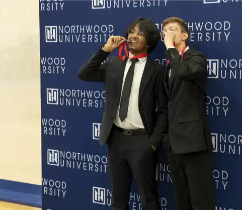 Northwood University students celebrating an award in front of the Northwood University backdrop