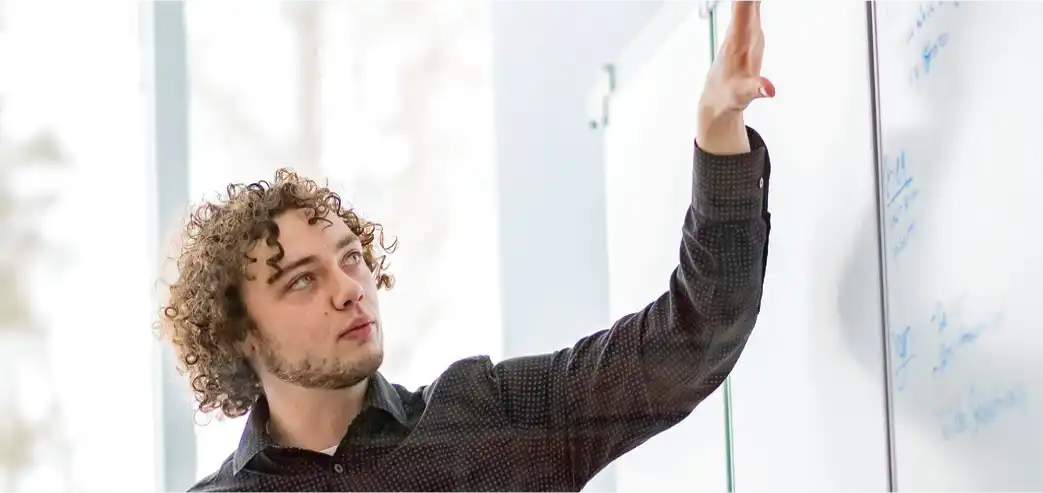 A Northwood University student presenting at a whiteboard during class