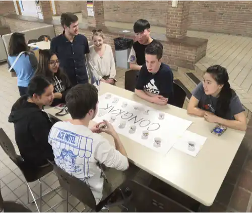 Northwood University students celebrating around a table with a 'Congrats' sign